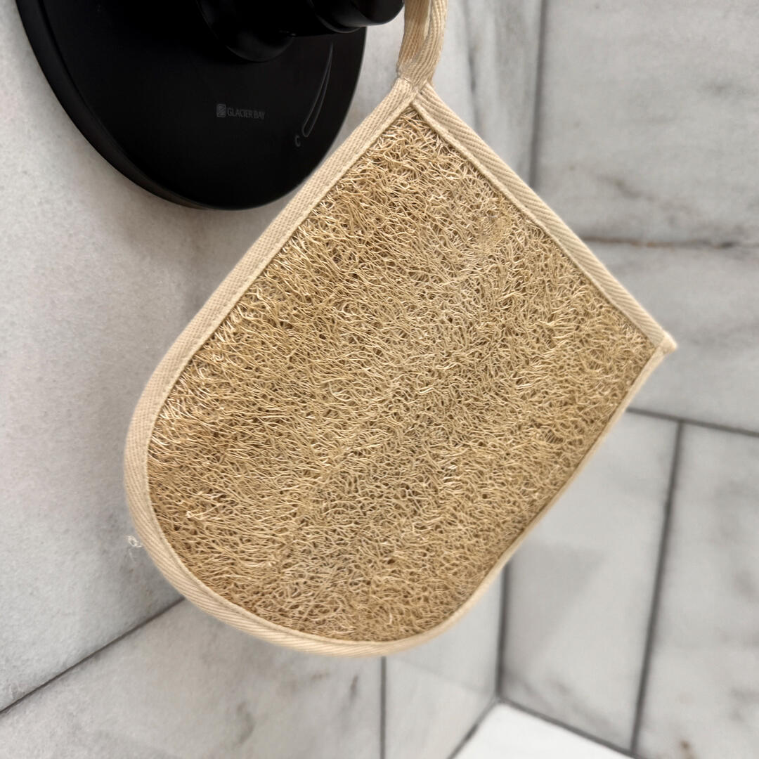 Exfoliate mitten hanging from a shower knob